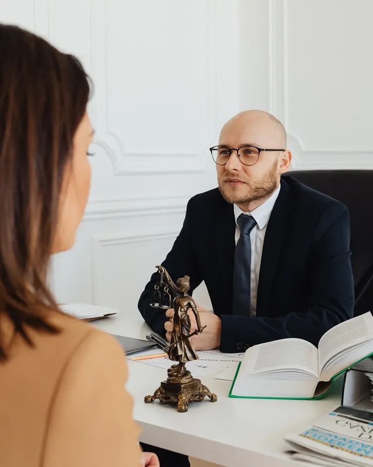 man-suit-sits-desk-with-woman-suit-glasses