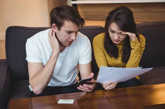 couple-sitting-sofa-discussing-with-financial-documents-living-room